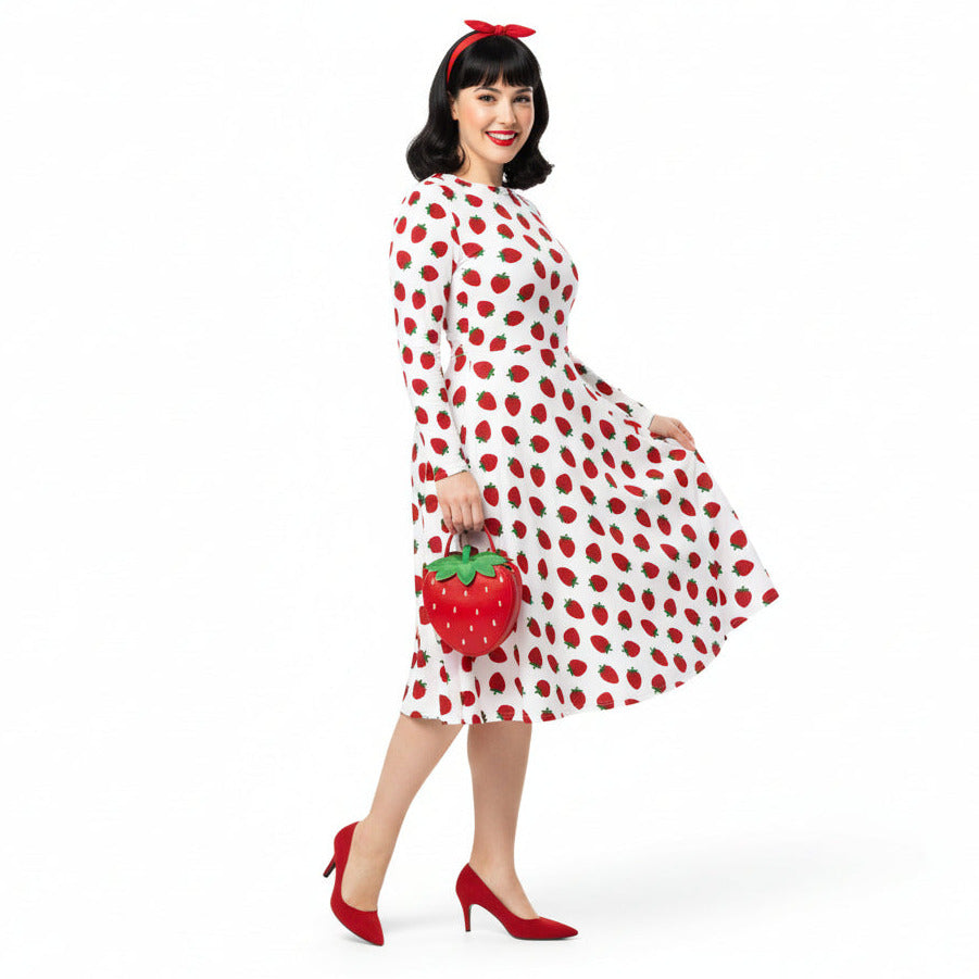 Woman wearing white and red strawberry print long sleeve dress on white background