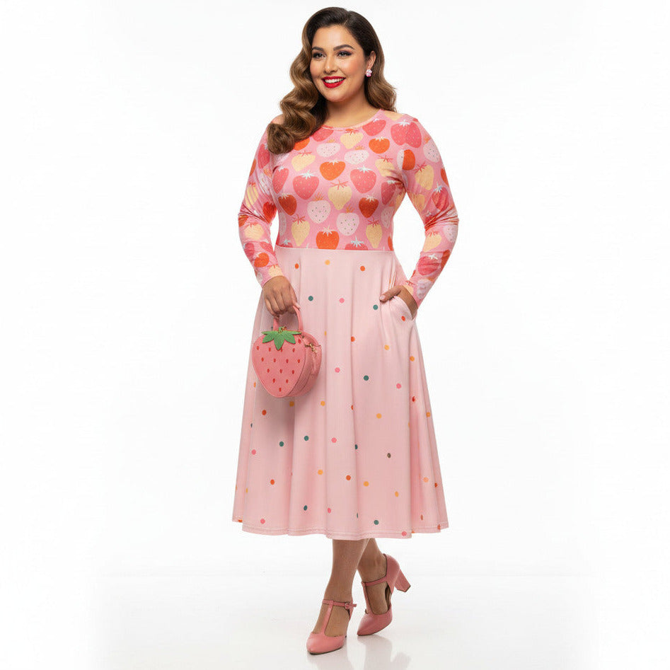 Plus size woman wearing pink and red strawberry print long sleeve pin up dress with pockets