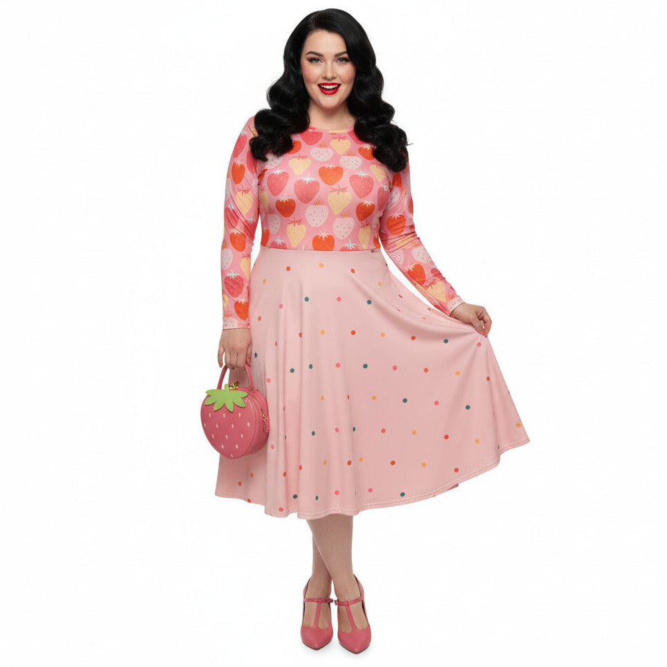 Woman wearing pink and red strawberry print long sleeve pin up dress with pockets