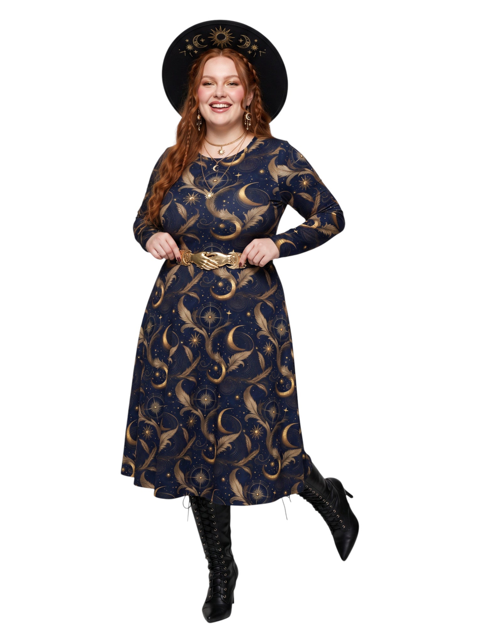 A woman modeling a long-sleeve midi dress with a celestial print, featuring a dark navy blue background with gold crescent moons, stars, and sun motifs. She is accessorized with a gold belt, a wide-brimmed black sun hat, and black lace-up boots, set against a plain white background.