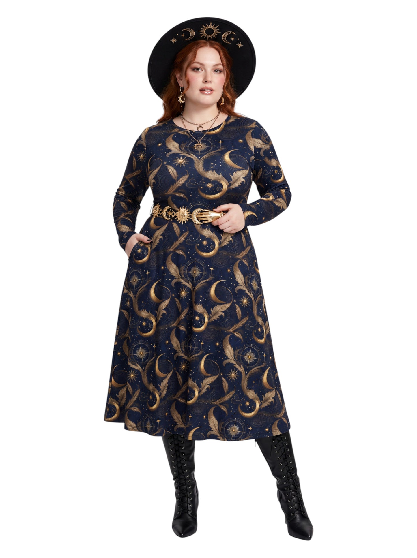 A woman modeling a long-sleeve navy midi dress with a gold celestial print of crescent moons, stars, and birds, styled with a gold belt, a black witch hat, and black boots against a white background.