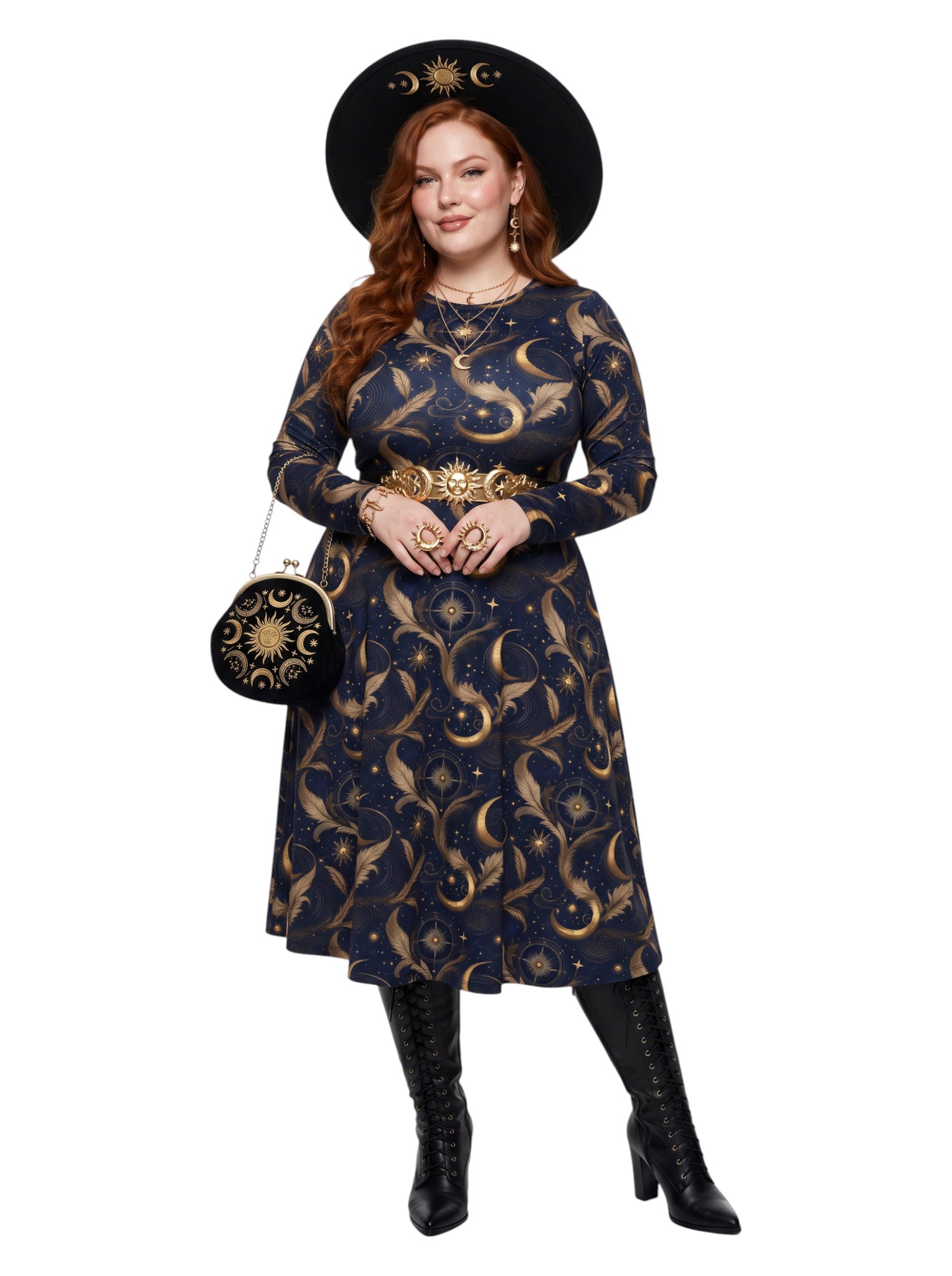 A woman modeling a dark navy blue midi dress with a gold celestial print of crescent moons and stars, styled with a wide-brimmed black hat, gold belt, black boots, and a matching moon-themed handbag against a plain white background.