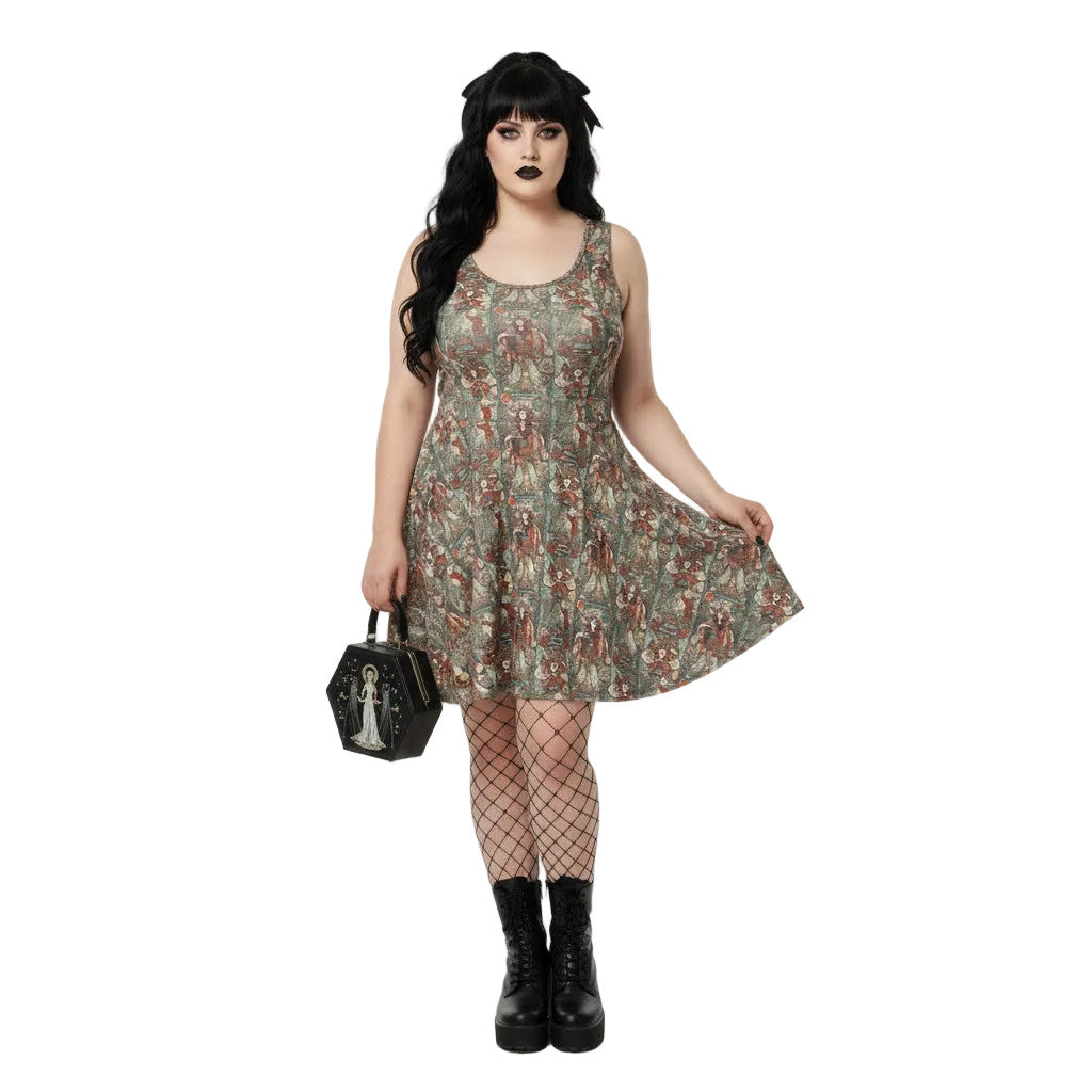 Woman wearing a green Whimsigoth tarot card print skater dress with black fishnets and a gothic handbag.