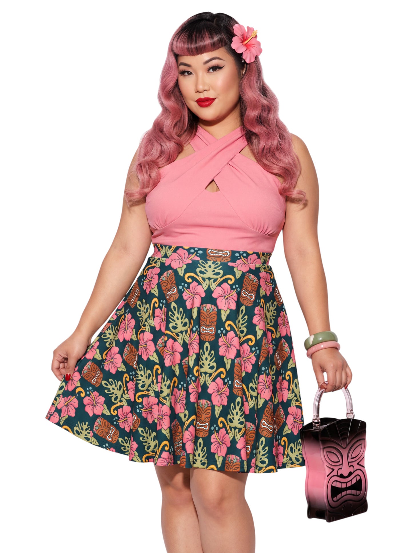 Plus-size woman wearing high-waisted tiki mask and hibiscus flower print pinup swing skirt with pink halter top.