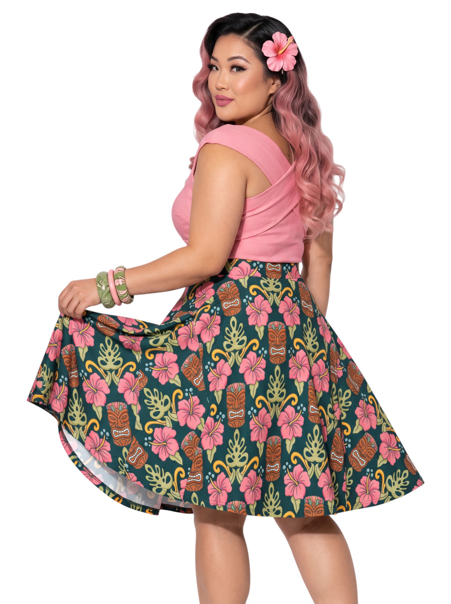 Plus-size woman wearing high-waisted tiki mask and hibiscus flower print pinup swing skirt with pink halter top.