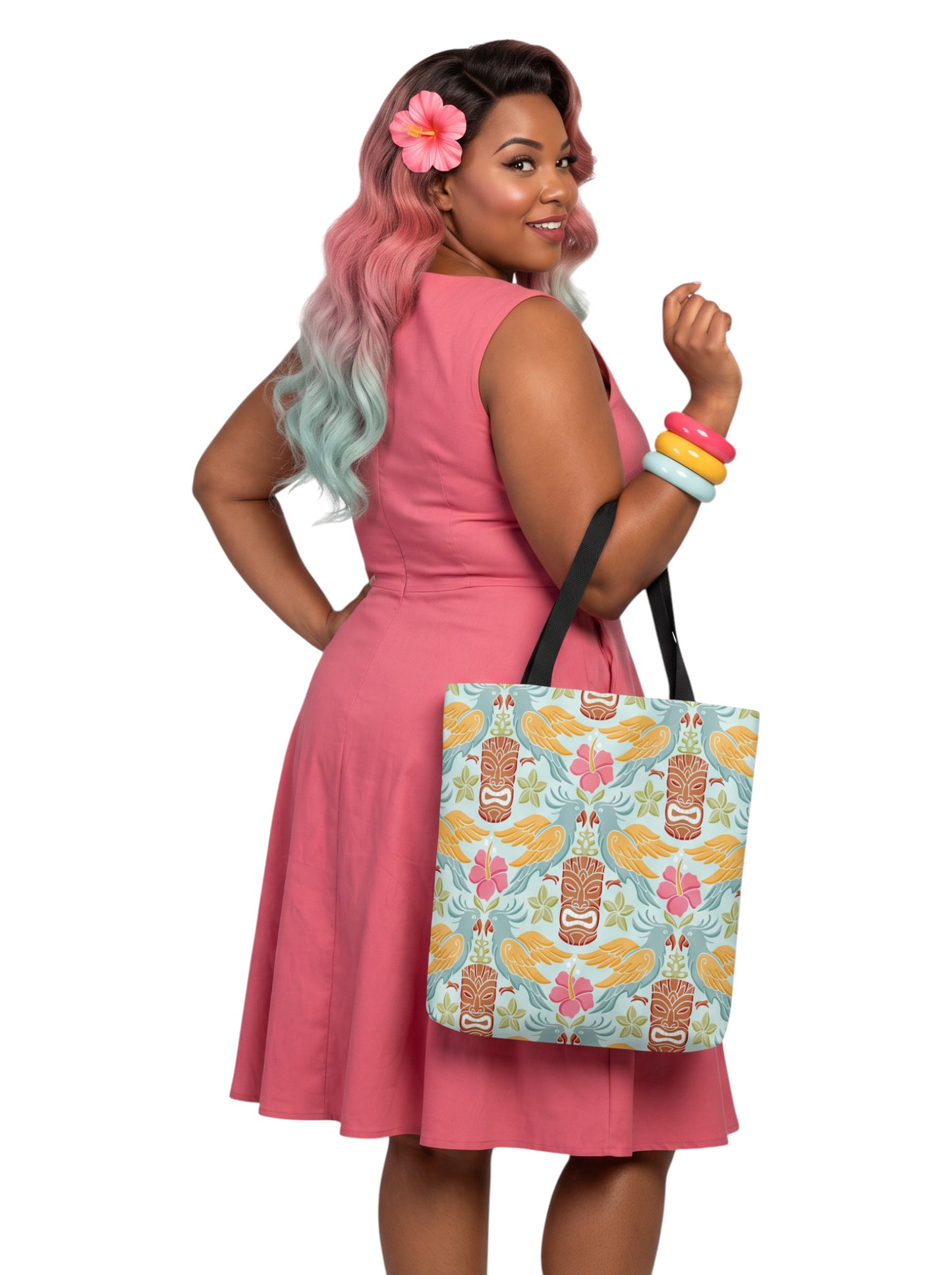 A woman holding a Tiki mask bird and hibiscus flower pattern tropical pinup tote bag with black handles.
