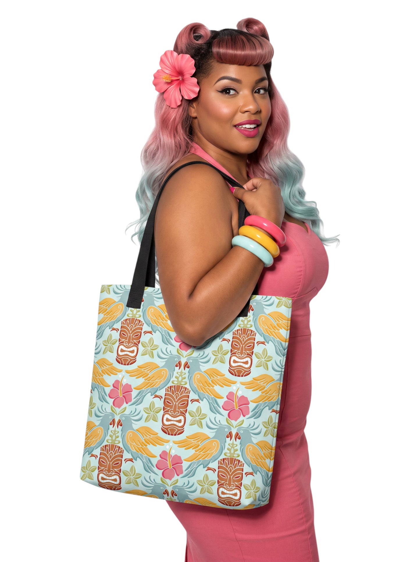 A woman holding a Tiki mask bird and hibiscus flower pattern tropical pinup tote bag with black handles.