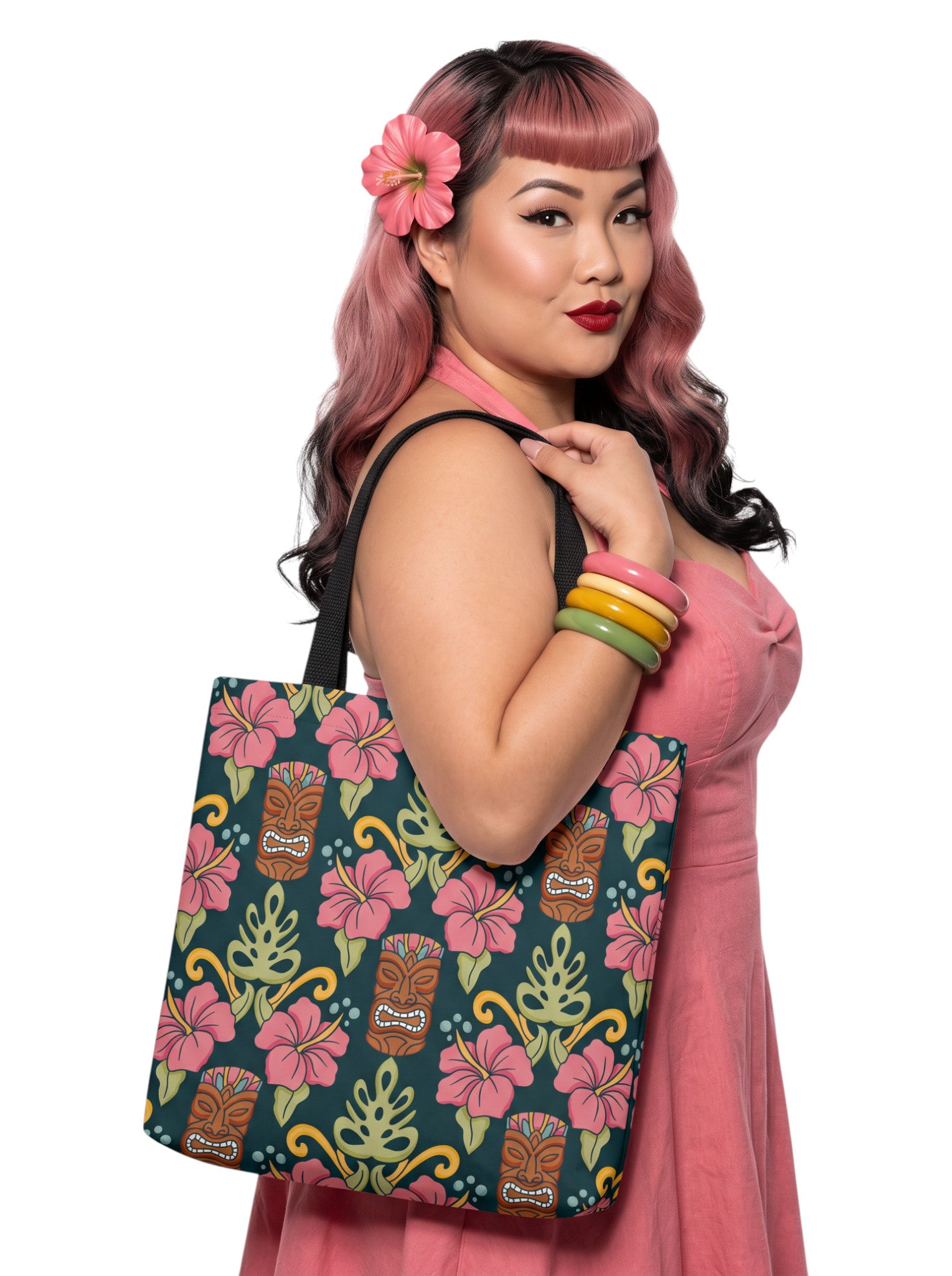 A woman holding a Tiki mask hibiscus flower pinup style tropical beach tote bag with black handles.