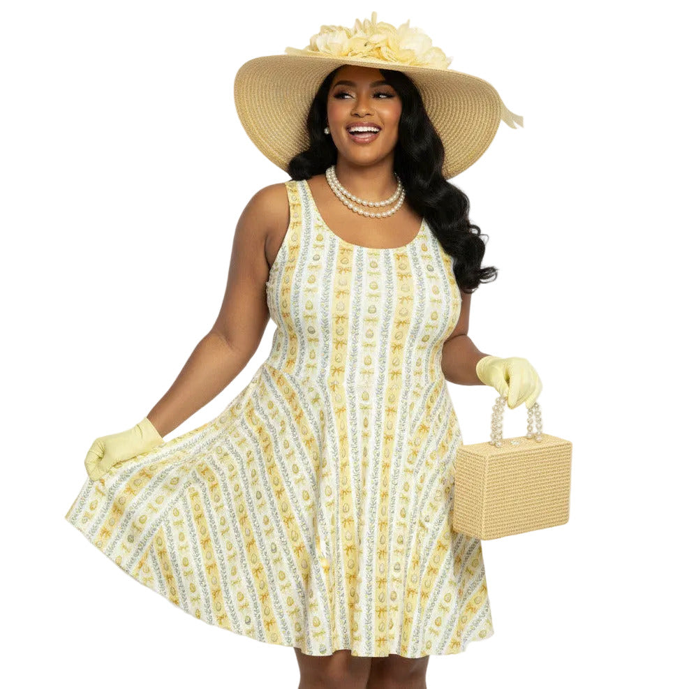 Plus size woman wearing a yellow 1950s vintage-inspired fit and flare dress with an Easter egg pattern, styled with a straw hat and pearls.