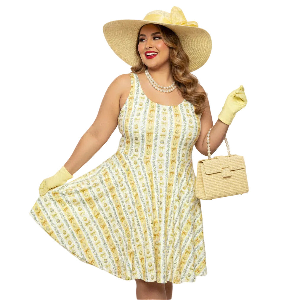 Plus size woman wearing a yellow 1950s vintage-inspired fit and flare dress with an Easter egg pattern, styled with a straw hat and pearls.