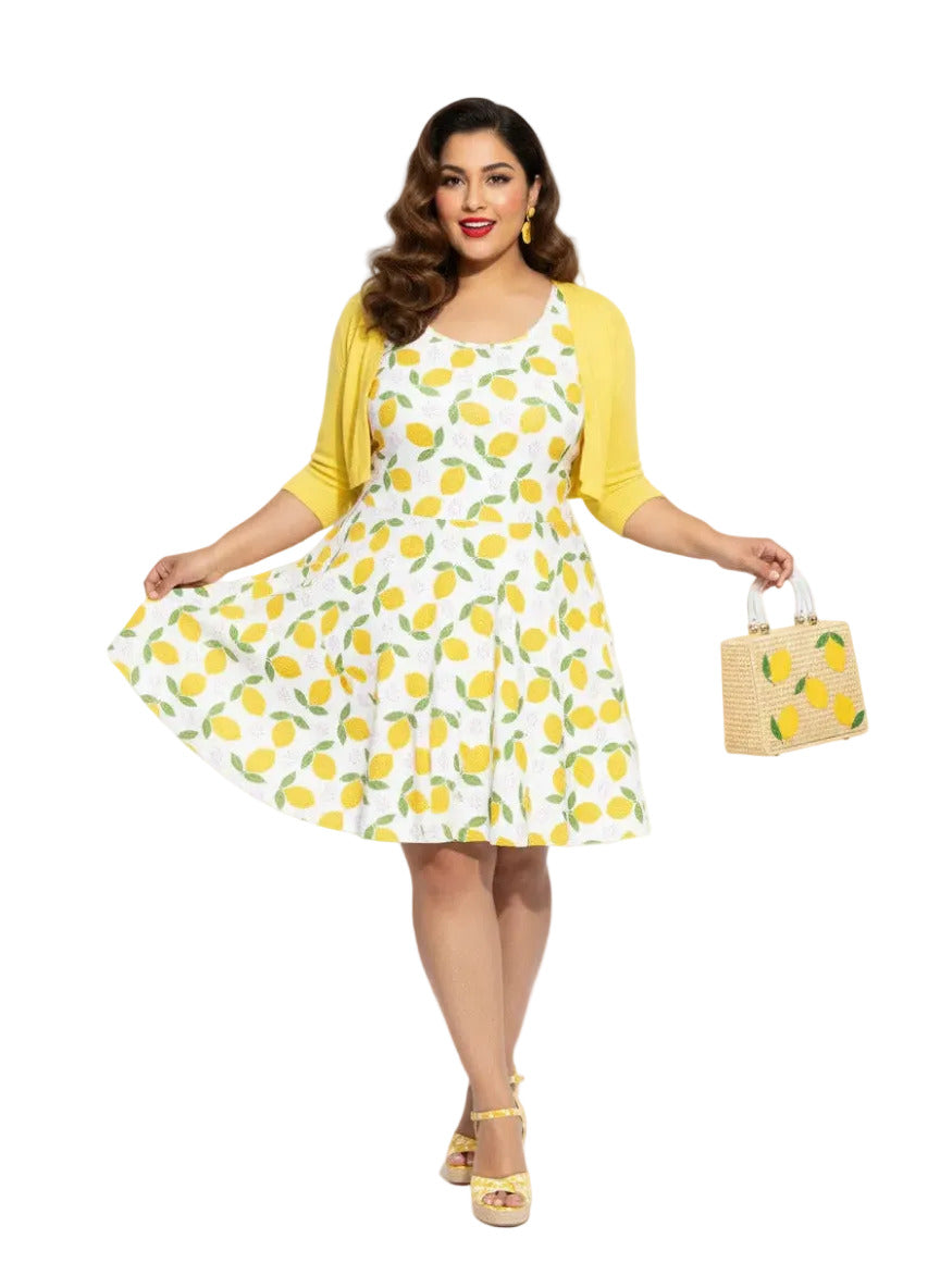 Plus size woman in a 1950s lemon print vintage swing dress with a fit and flare silhouette and yellow citrus pattern.
