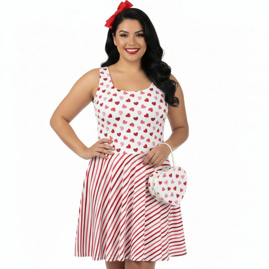 Woman wearing a red and white dress with heart pattern, holding a matching handbag on a white background