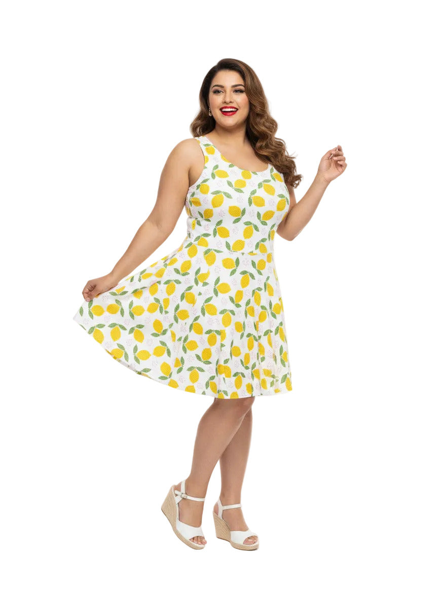 Plus size woman in a 1950s lemon print vintage swing dress with a fit and flare silhouette and yellow citrus pattern.