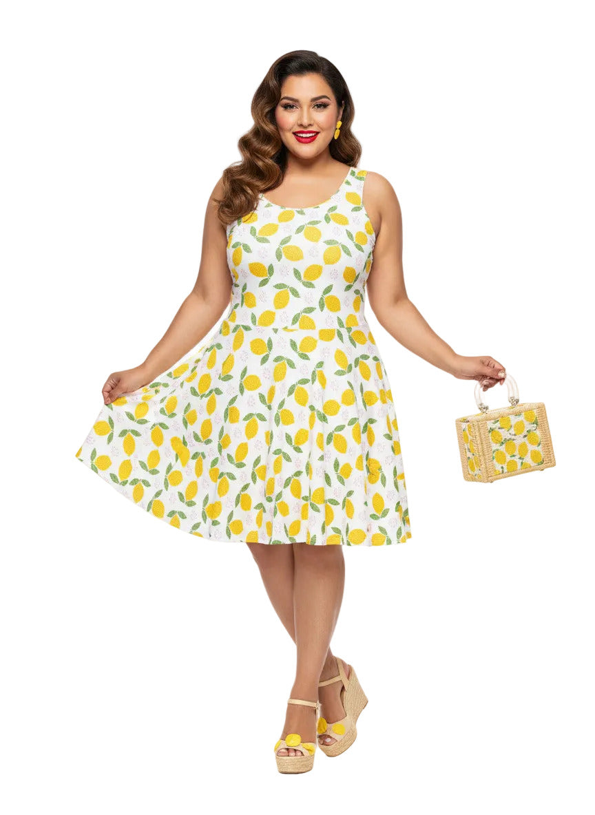 Plus size woman in a 1950s lemon print vintage swing dress with a fit and flare silhouette and yellow citrus pattern.