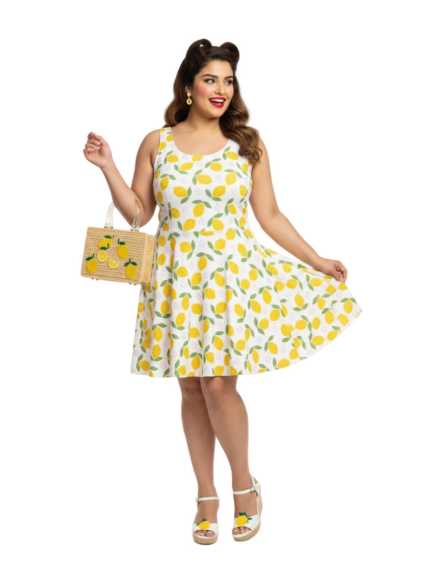 Plus size woman in a 1950s lemon print vintage swing dress with a fit and flare silhouette and yellow citrus pattern.