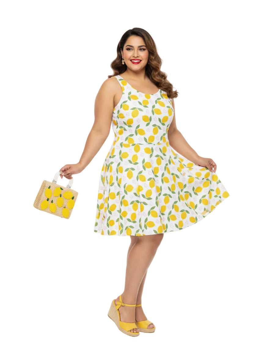 Plus size woman in a 1950s lemon print vintage swing dress with a fit and flare silhouette and yellow citrus pattern.