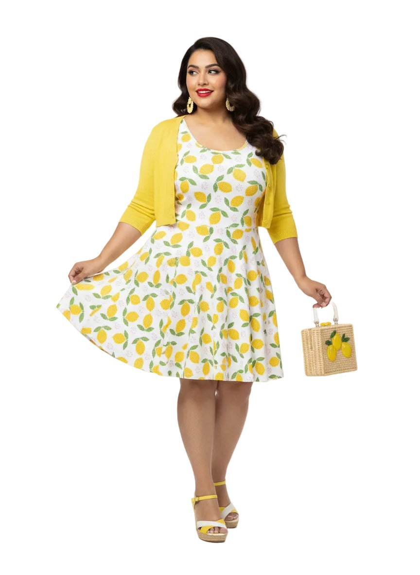 Plus size woman in a 1950s lemon print vintage swing dress with a fit and flare silhouette and yellow citrus pattern.
