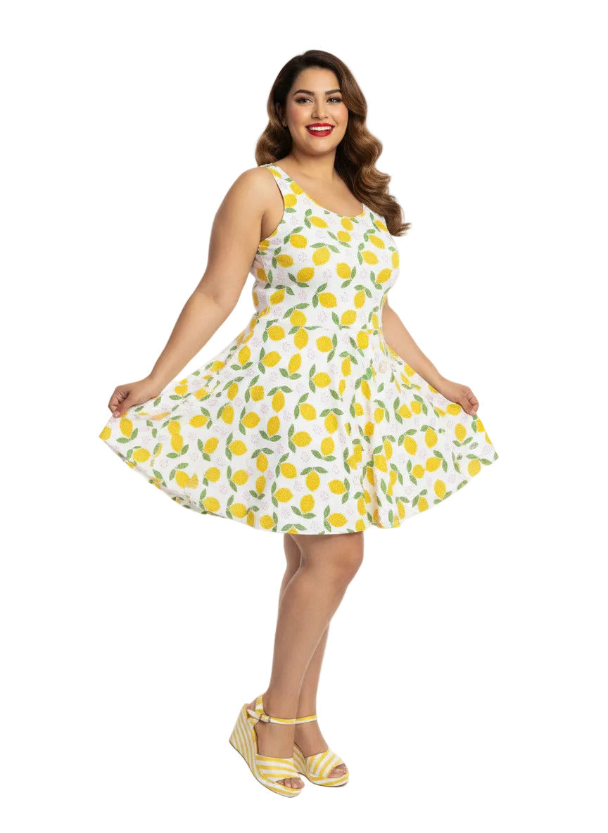 Plus size woman in a 1950s lemon print vintage swing dress with a fit and flare silhouette and yellow citrus pattern.