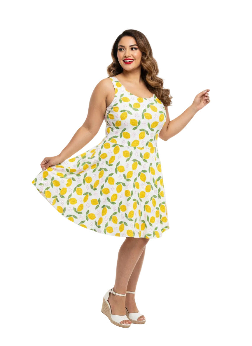 Plus size woman in a 1950s lemon print vintage swing dress with a fit and flare silhouette and yellow citrus pattern.