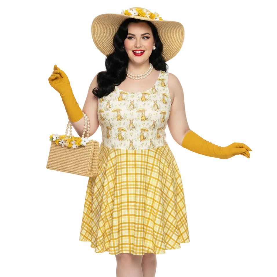 Plus size woman wearing a yellow gingham and Mr. Rabbit print 1950s vintage style fit and flare swing dress with straw hat.
