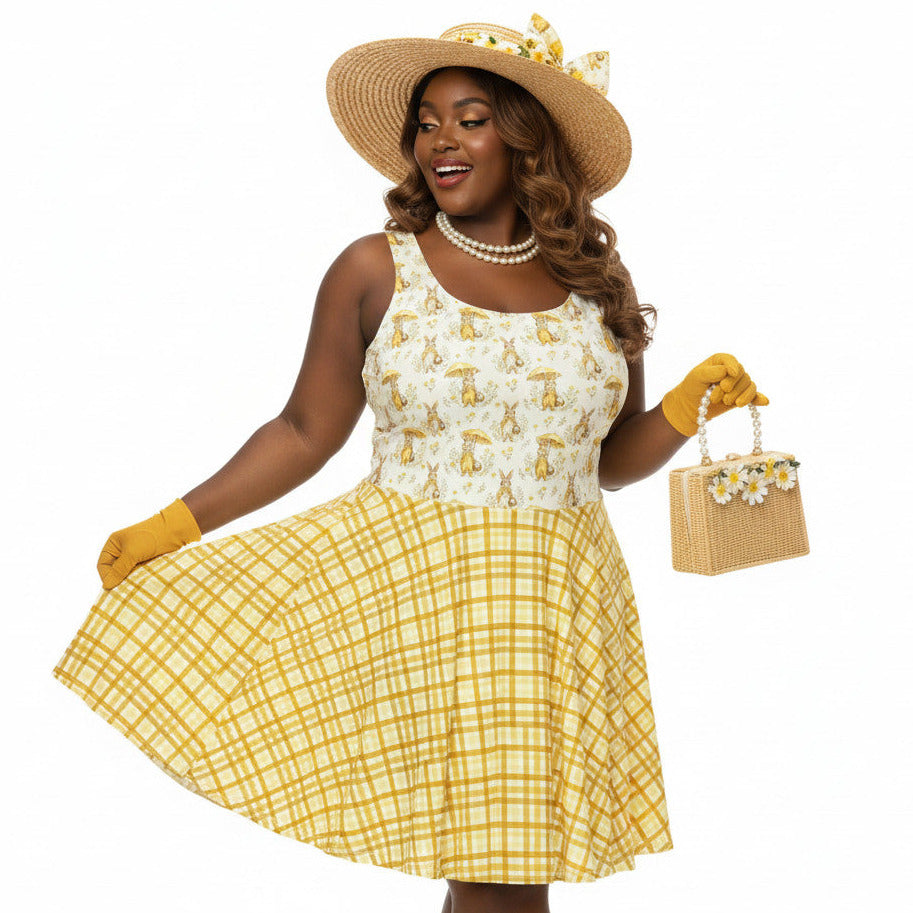 Plus size woman wearing a yellow gingham and Mr. Rabbit print 1950s vintage style fit and flare swing dress with straw hat.