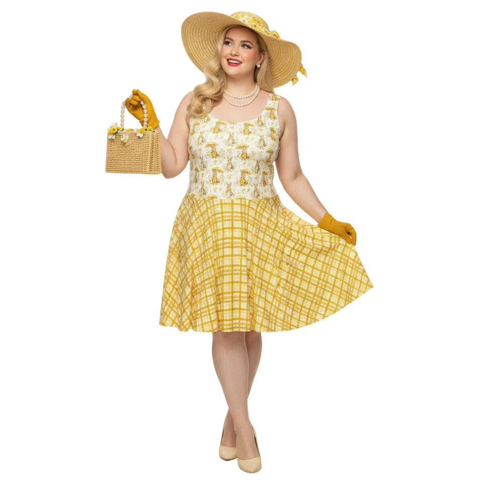 Plus size woman wearing a yellow gingham and Mr. Rabbit print 1950s vintage style fit and flare swing dress with straw hat.