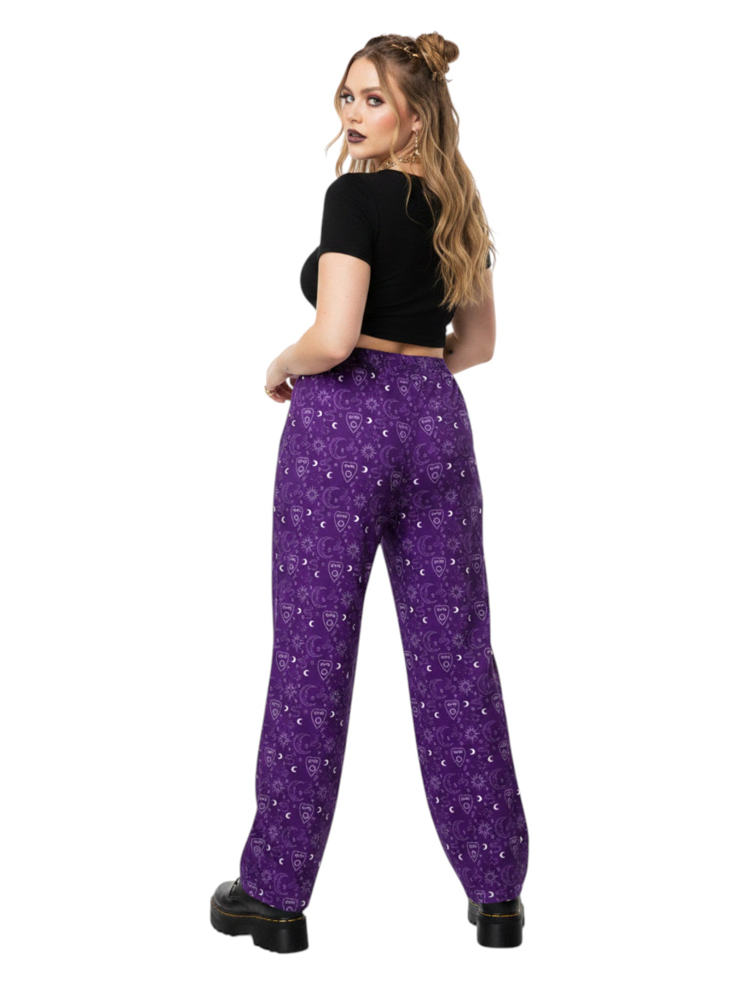 Woman wearing purple Whimsigoth wide leg lounge pants with celestial moon and sun print.