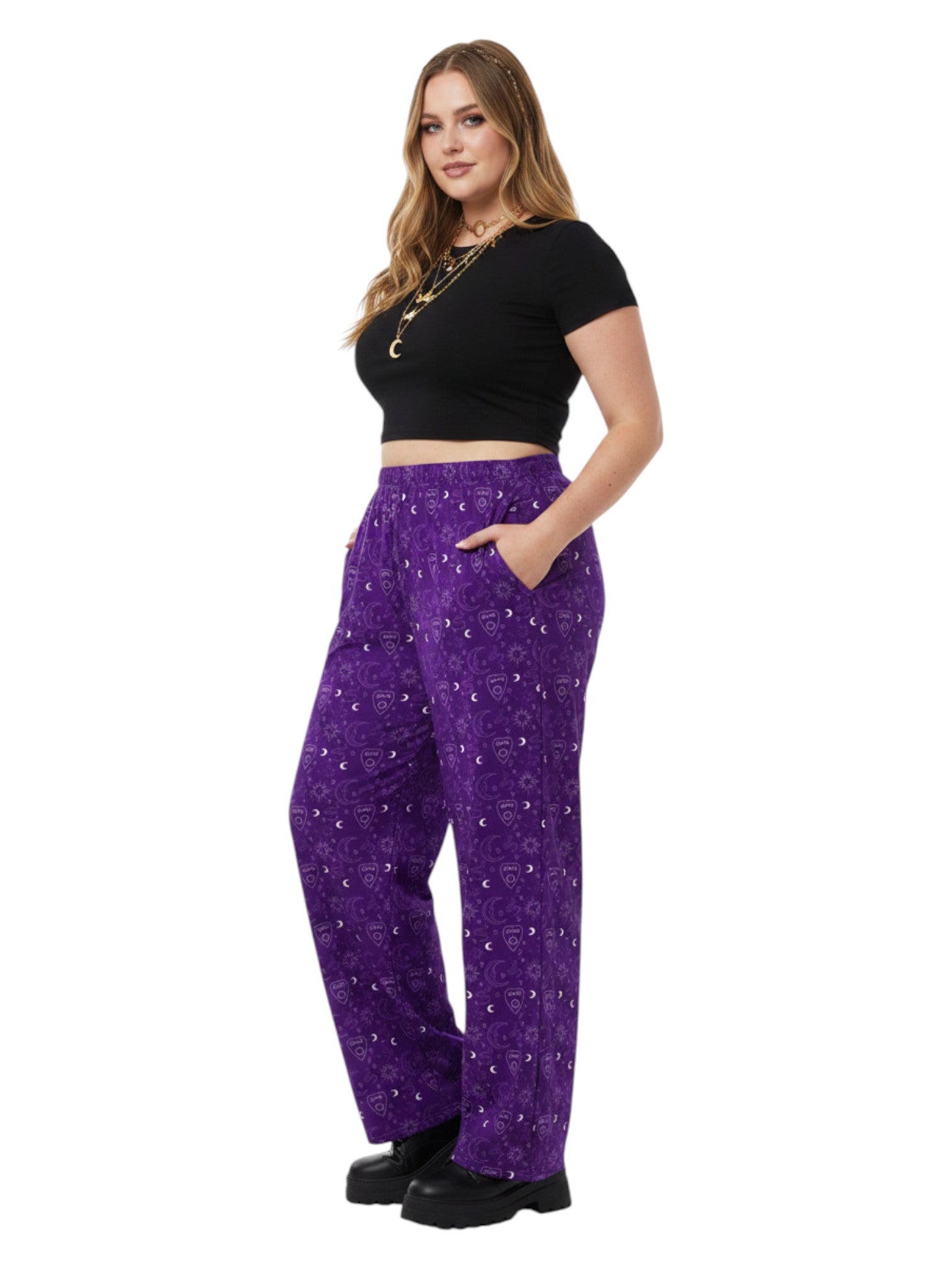 Woman wearing purple Whimsigoth wide leg lounge pants with celestial moon and sun print.