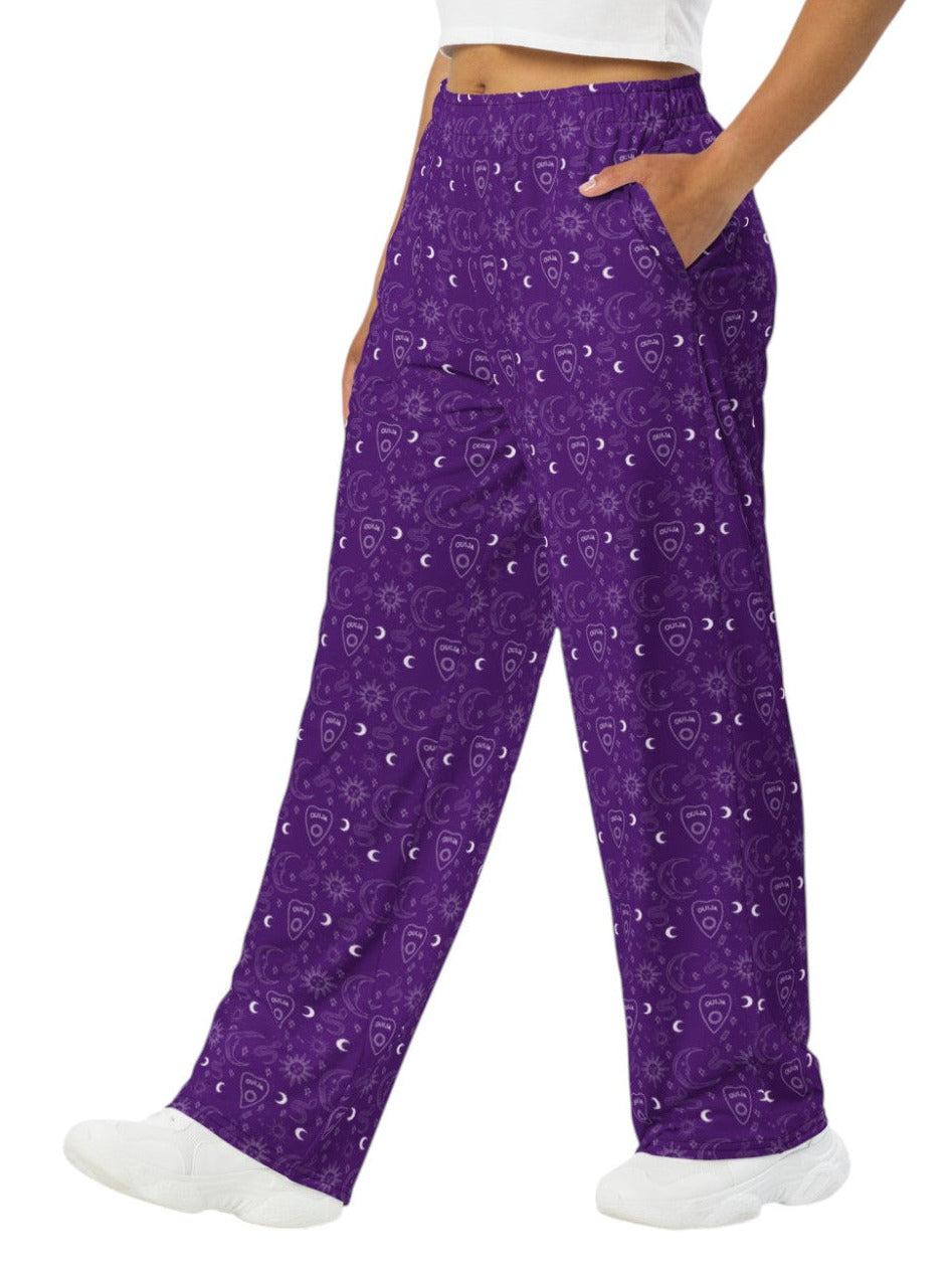 Woman wearing purple Whimsigoth wide leg lounge pants with celestial moon and sun print.