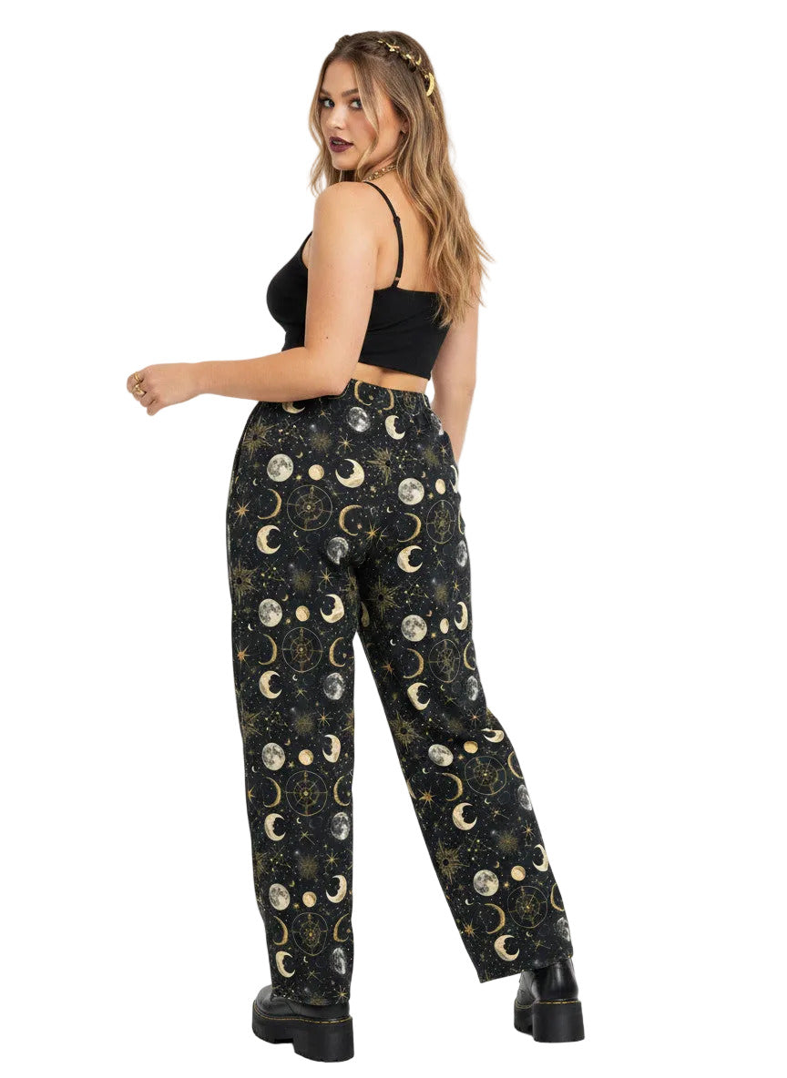 Woman wearing Whimsigoth celestial wide leg lounge pants with sun, moon, and star print.