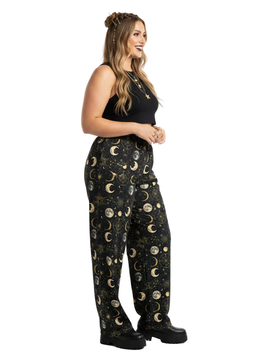 Woman wearing Whimsigoth celestial wide leg lounge pants with sun, moon, and star print.