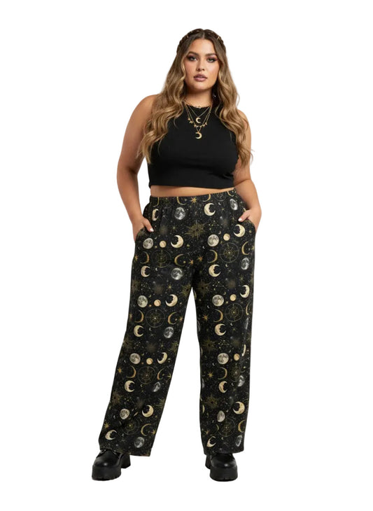 Woman wearing Whimsigoth celestial wide leg lounge pants with sun, moon, and star print.