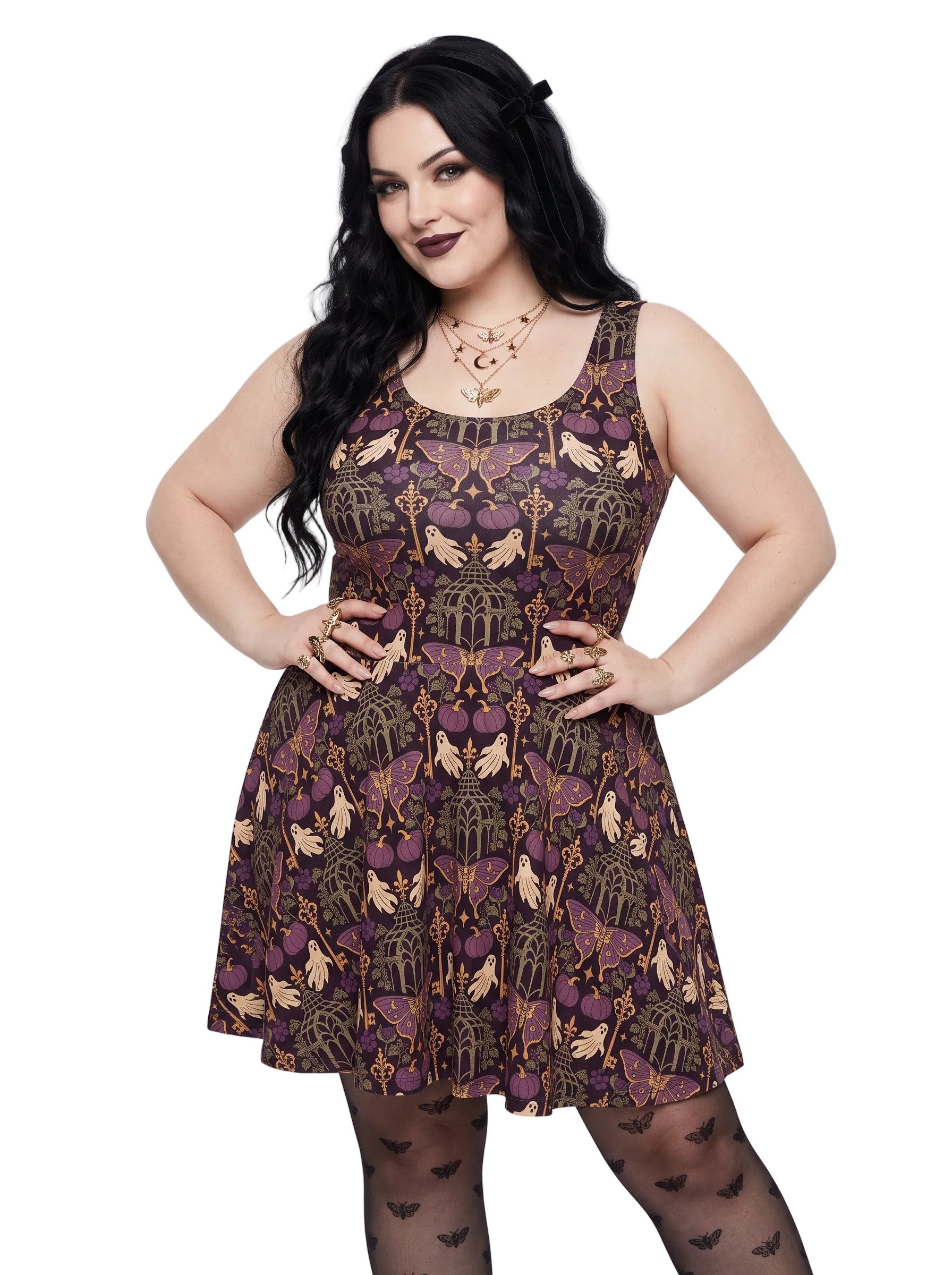 A woman wearing a dark purple gothic whimsigoth pattern featuring candelabras and moth, paired with black tights with moth prints.