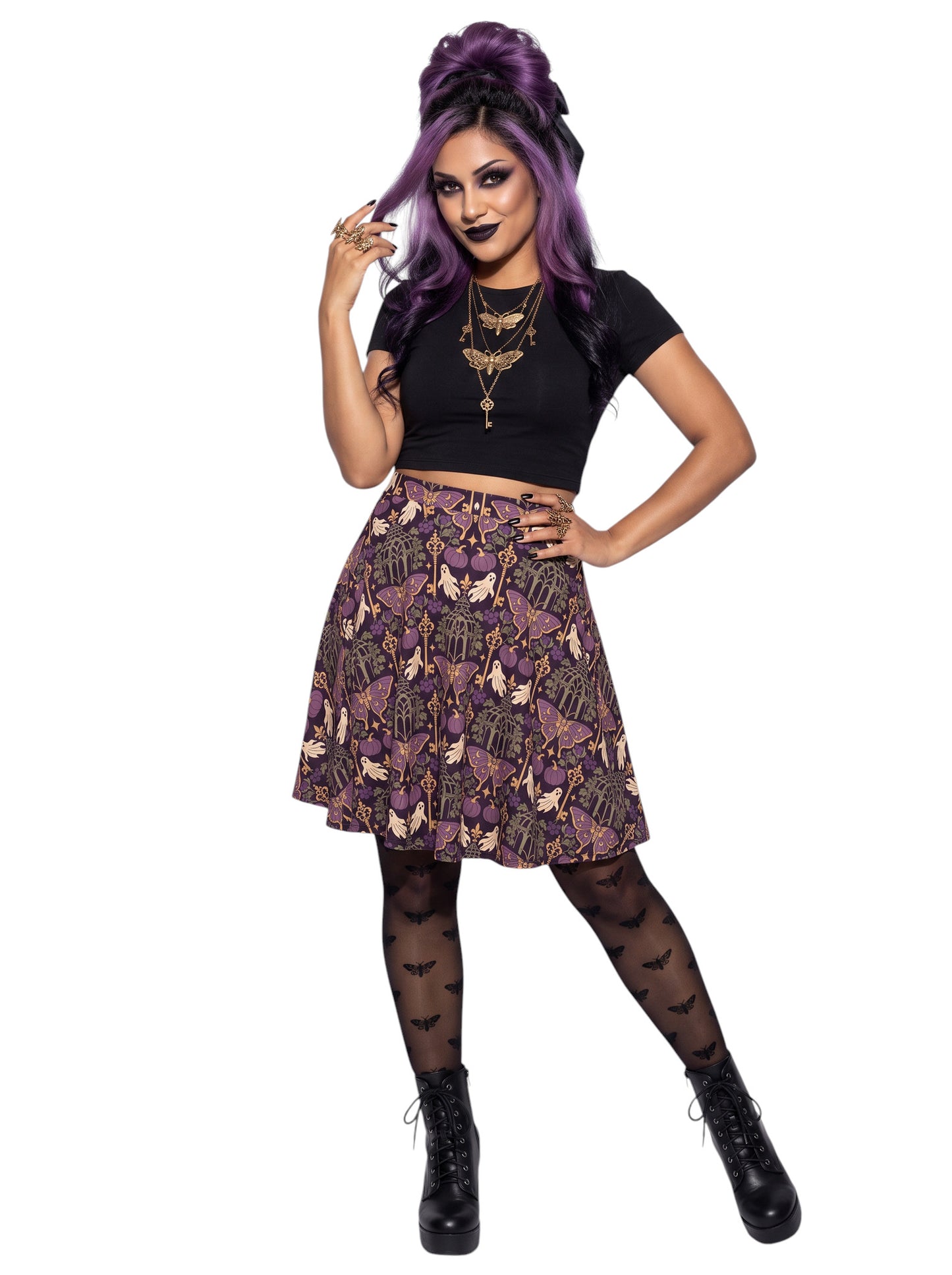Woman wearing a purple Whimsigoth moth print goth flare skirt with black crop top and moth tights.