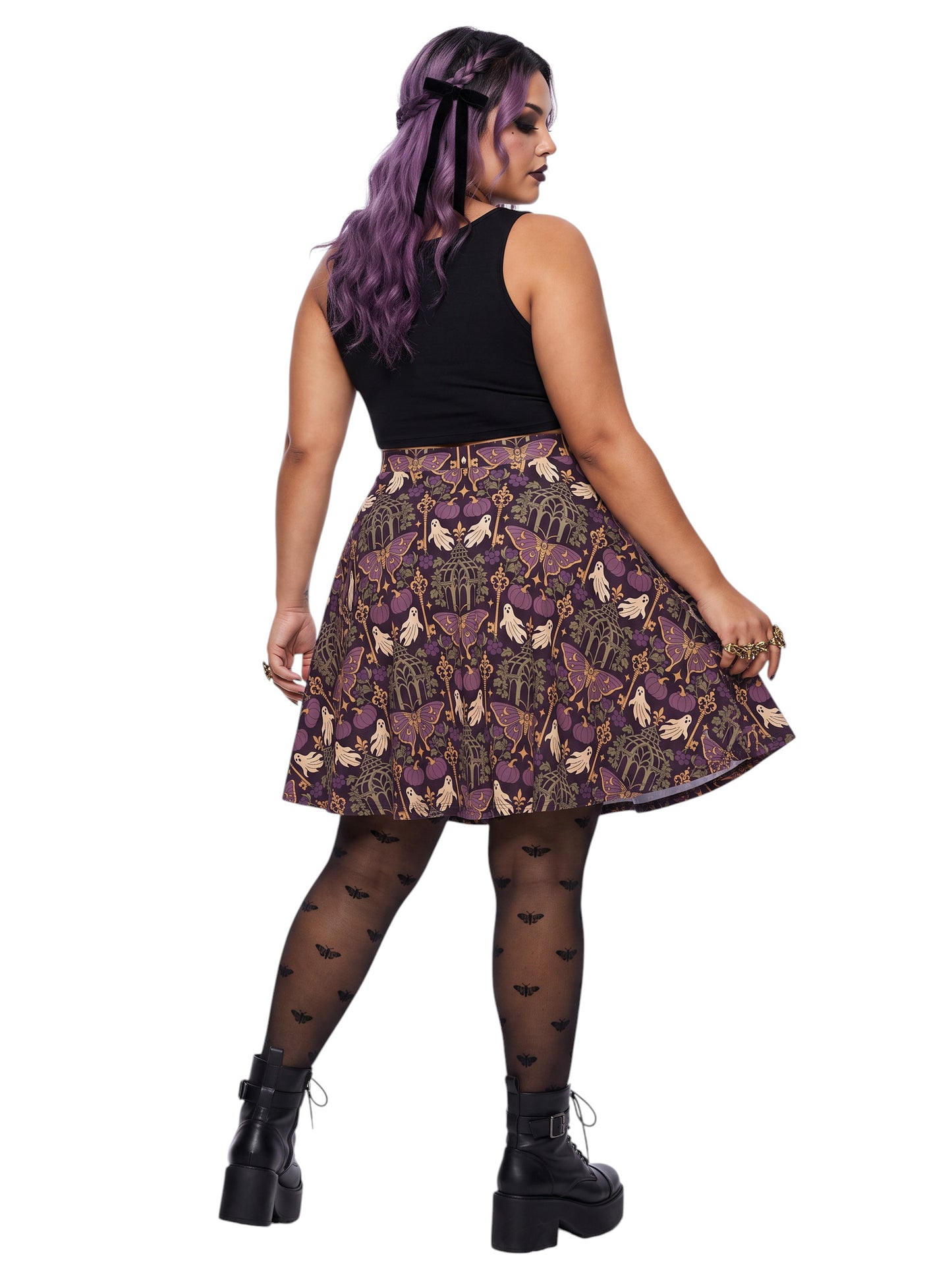 Woman wearing a purple Whimsigoth moth print goth flare skirt with black crop top and moth tights.