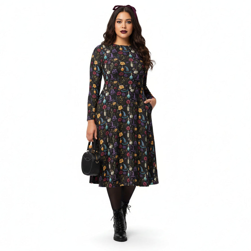 Woman wearing a patterned dress with a black handbag on a white background