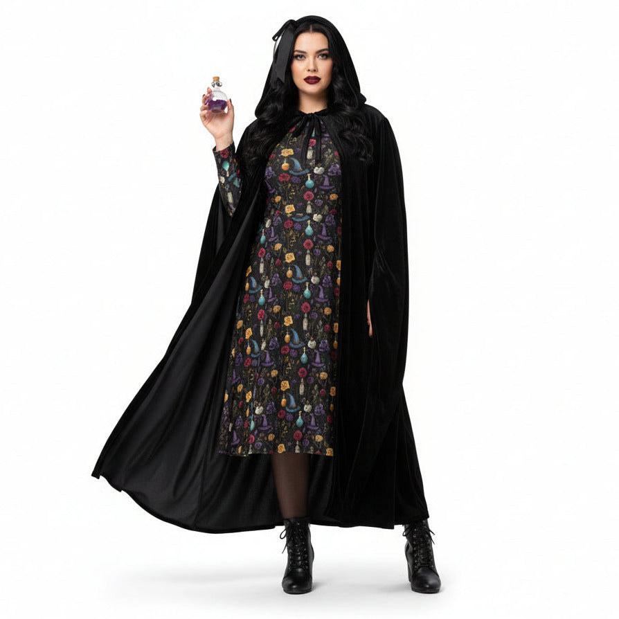 Woman in a black cape holding a bottle of perfume on a white background