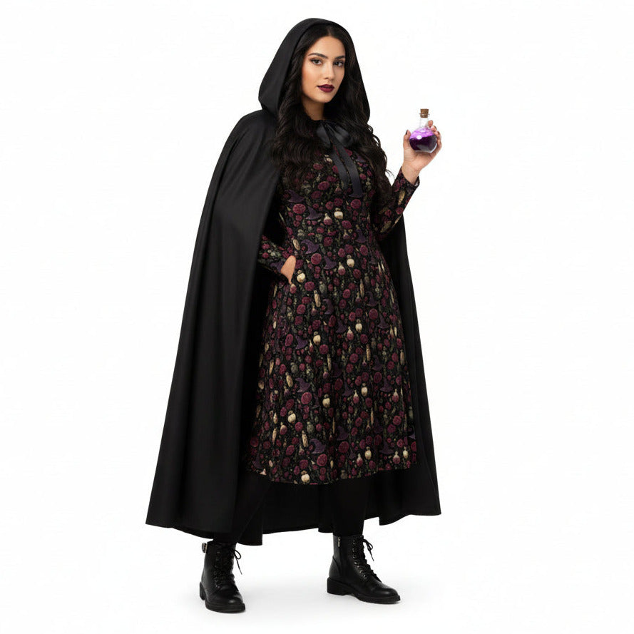 Person wearing a black cape and patterned dress holding a potion bottle on a white background