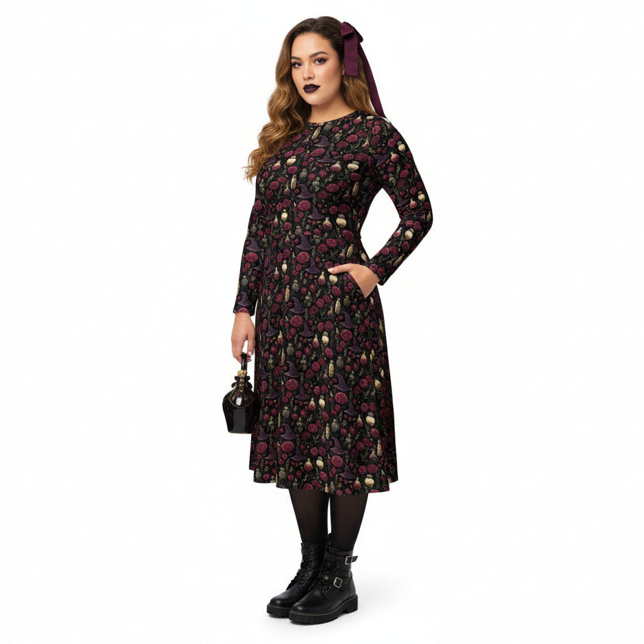 Woman wearing a dark floral dress with long sleeves on a white background