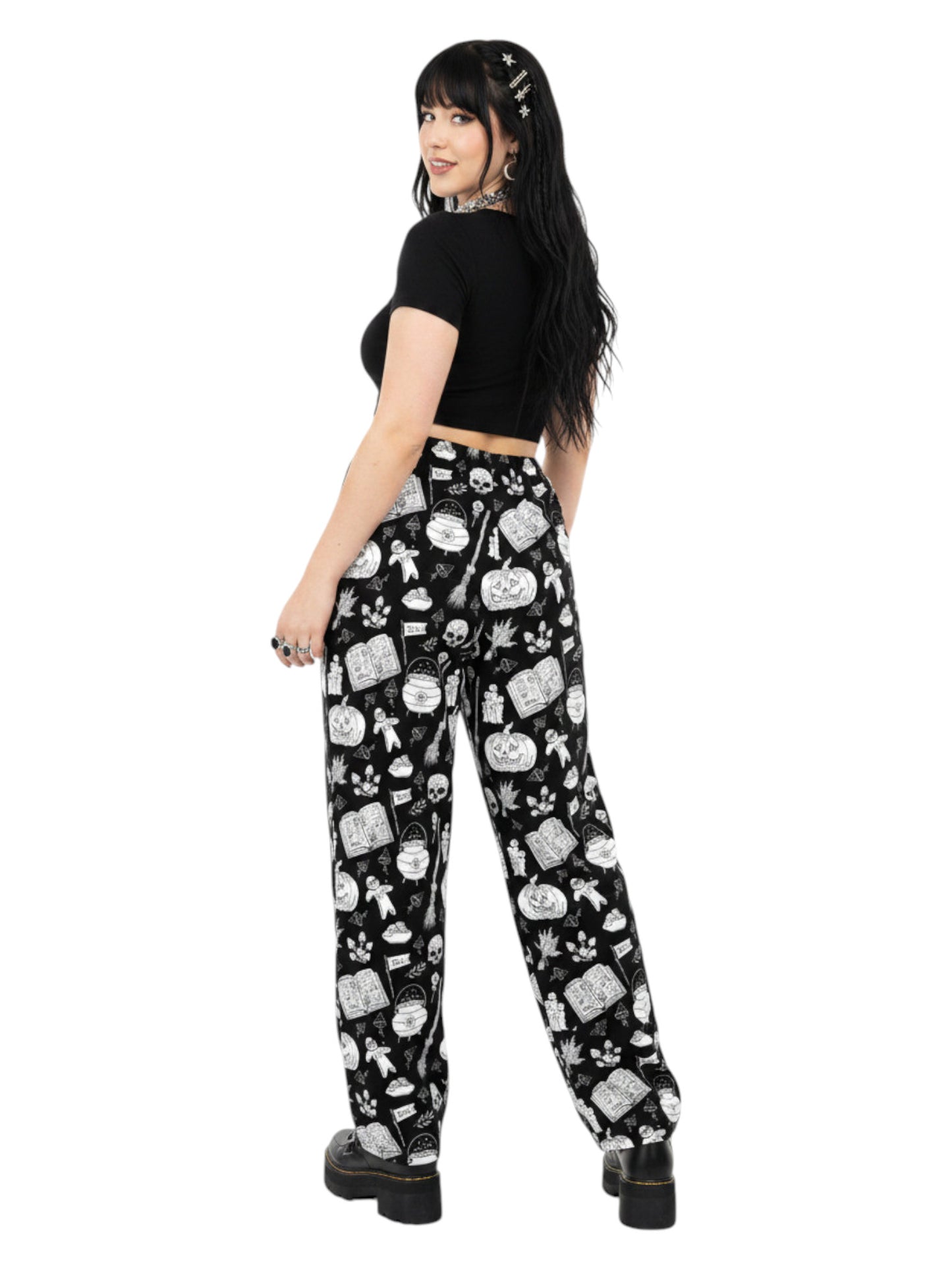 Woman wearing black and white witchy voodoo doll print wide leg lounge pants with side pockets.