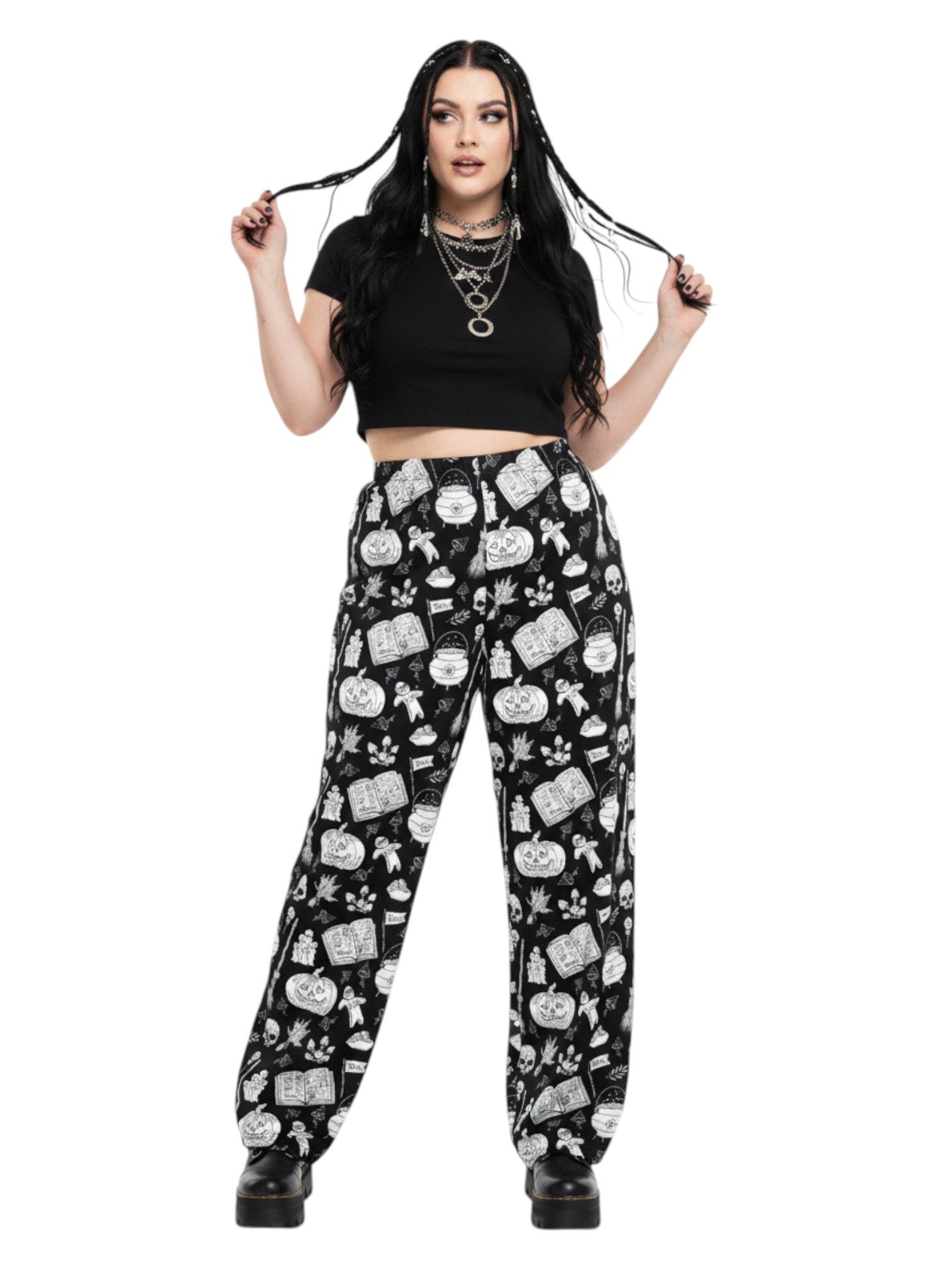 Woman wearing black and white witchy voodoo doll print wide leg lounge pants with side pockets.