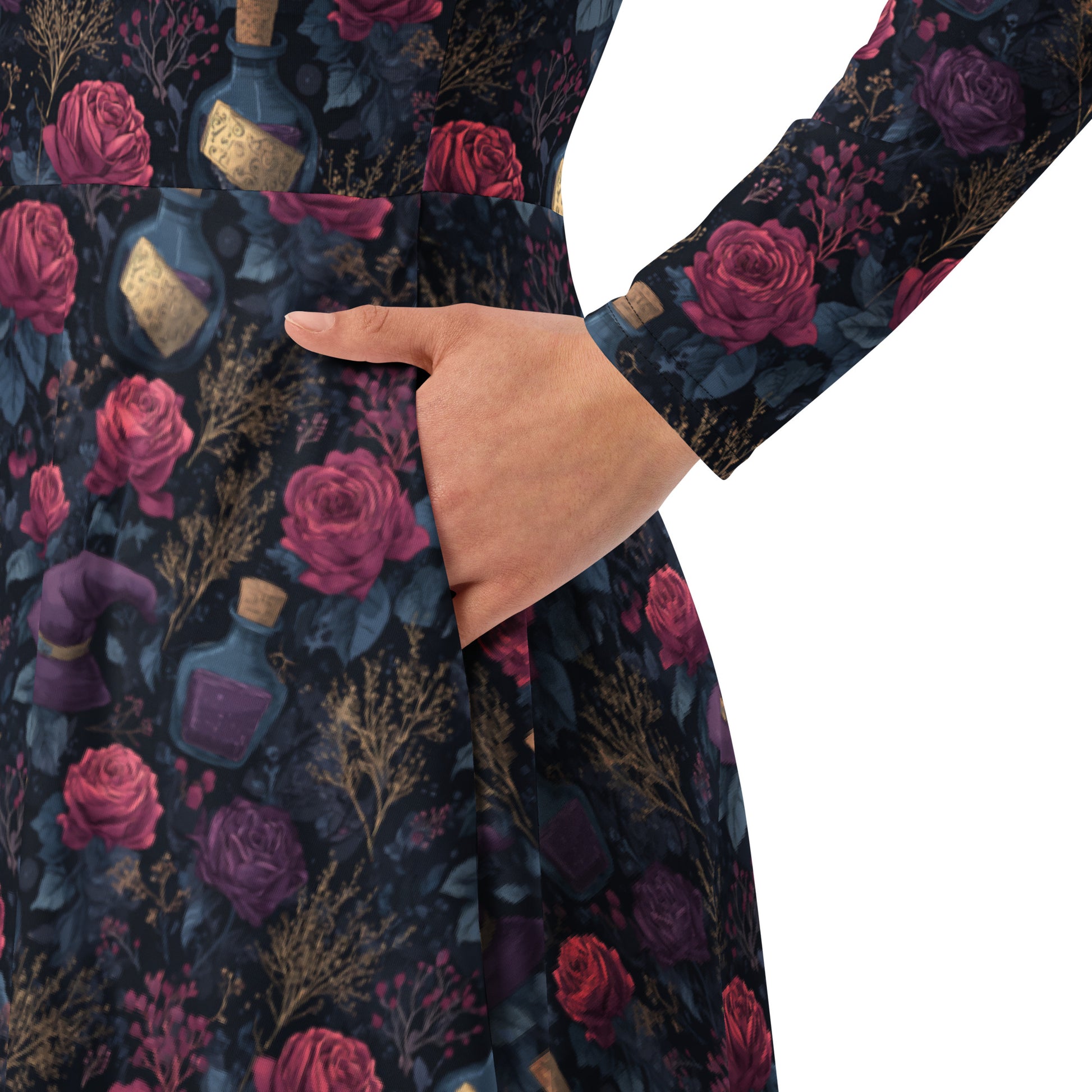 Close-up of a dark fabric with red roses and bottles pattern, held by a hand.